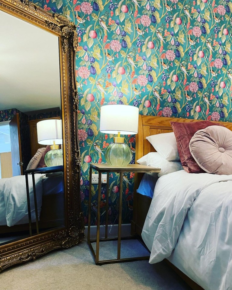 Kate's bedroom features stunning green wallpaper and gold mirror