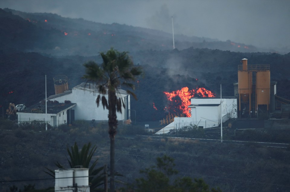 Lava rolls down behind a cement factory in Los Llanos