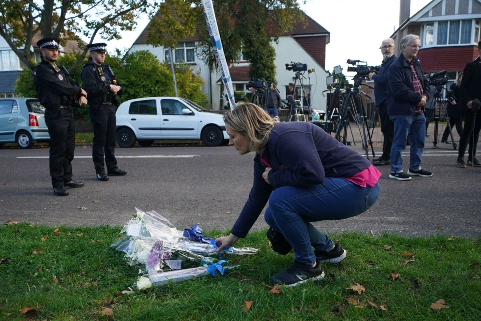 A constituent lays flowers near the scene of the attack