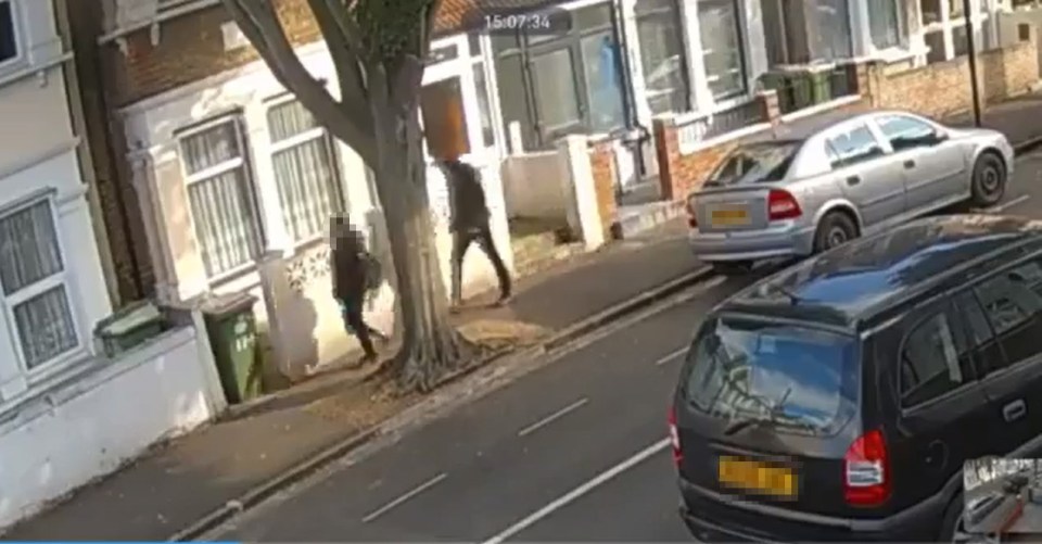 The hooded thief speeds up behind the woman before appearing to grab her neck