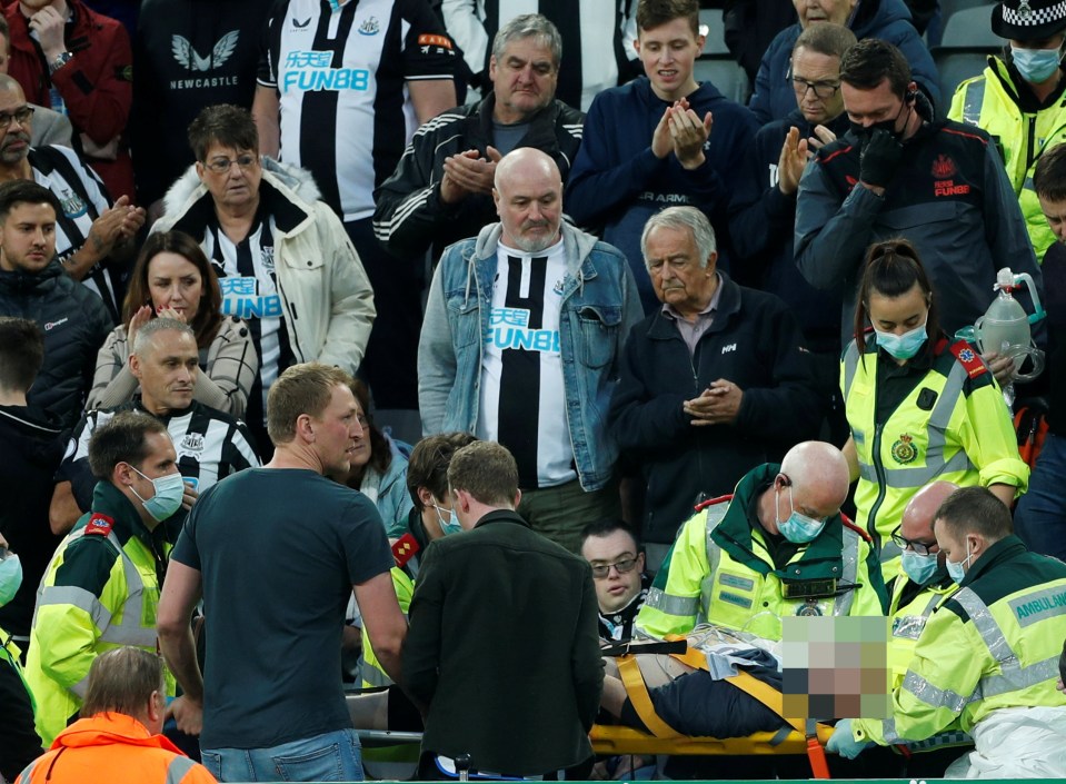 A Newcastle Utd fan is stretchered away from the stands by paramedics