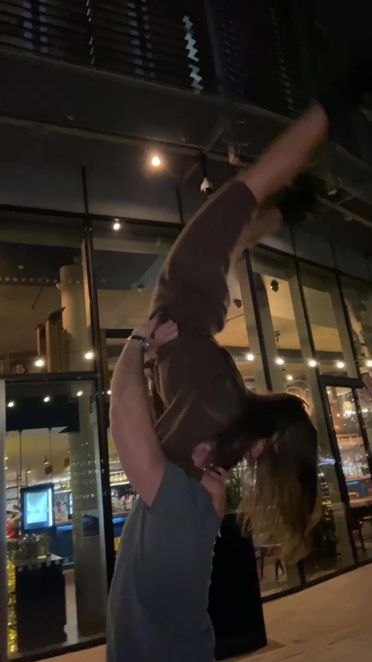 The man lifts her up in the air