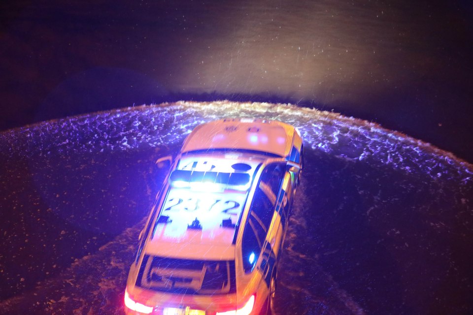 A police car wades through inches of water after a crash on the M23