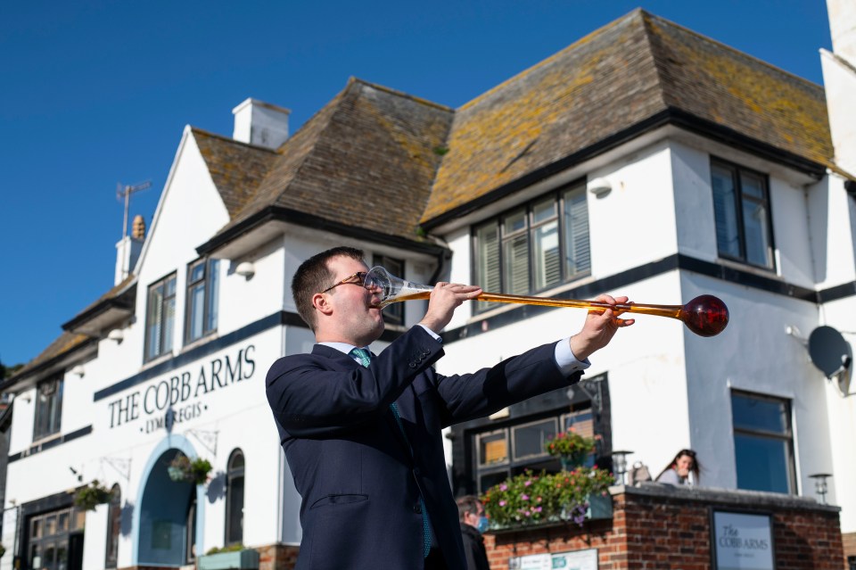 Sun reporter James downs a yard of ale outside The Cobb Arms in Lyme Regis where drinking the measure has been banned