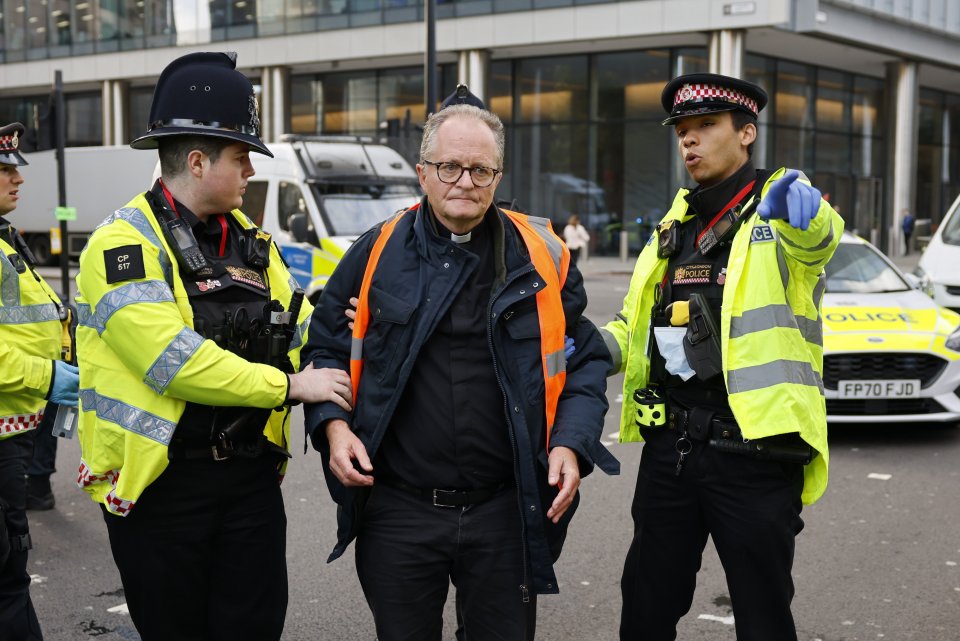 Police detain Insulate Britain activist Vicar Mark Coleman after he glued himself to the road