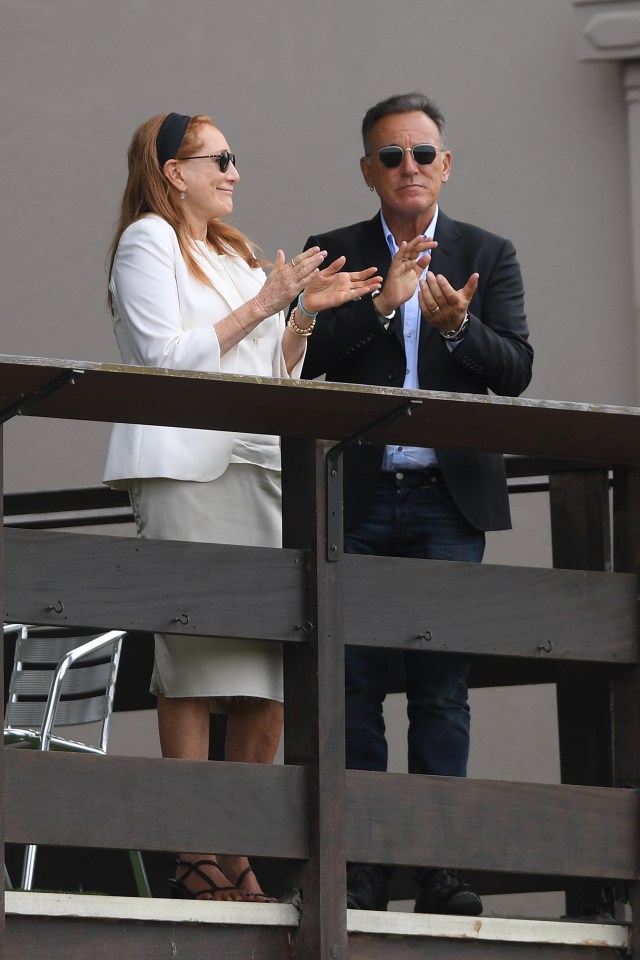 a man and a woman standing on a balcony applauding