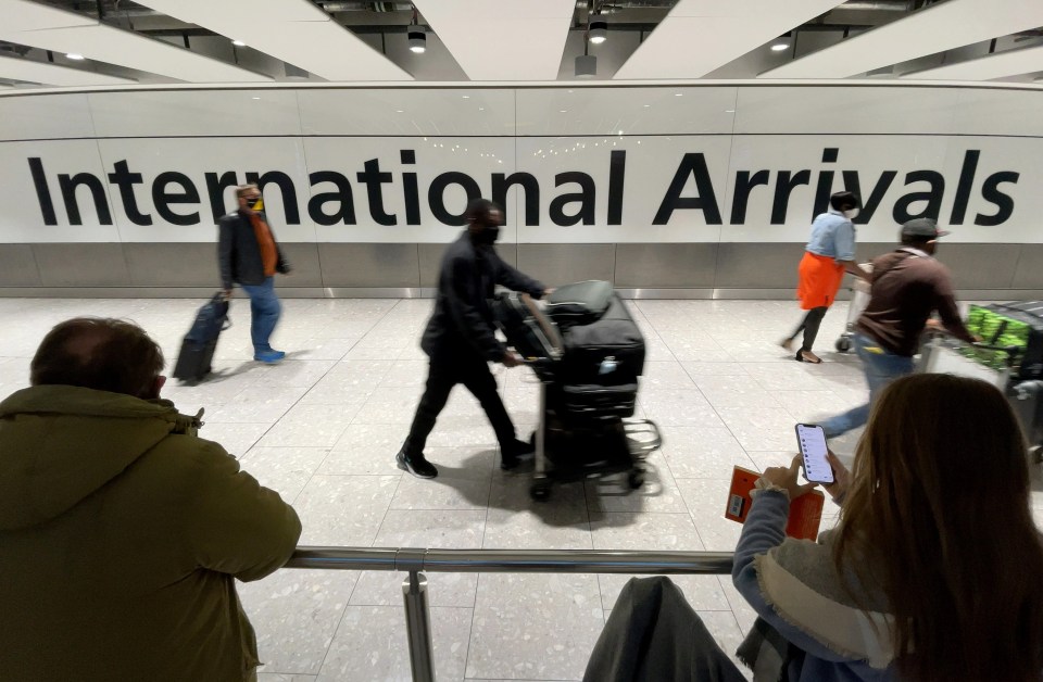 International passengers walk through the arrivals area at Terminal 5 at Heathrow Airport on November 26