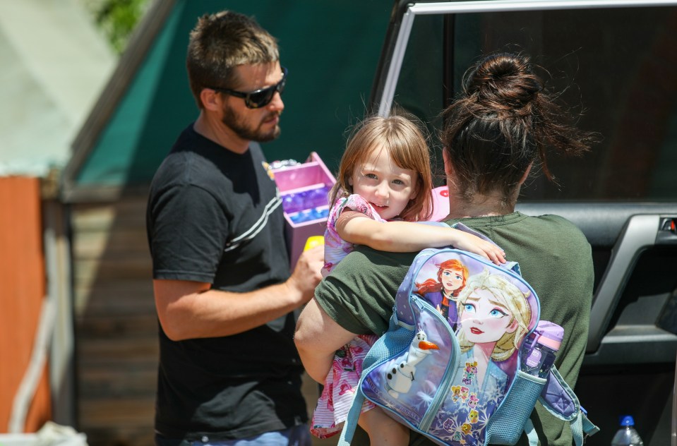 Cleo Smith is carried inside a friend's house by her mother