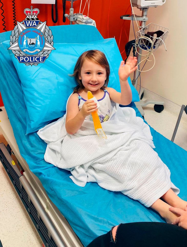 The four-year-old waves as she sits in hospital after her rescue