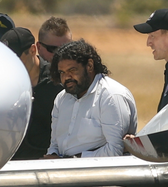 Terence Darrell Kelly boards a plane yesterday after being taken into custody by members of the Special Operations Group at Carnarvon airport