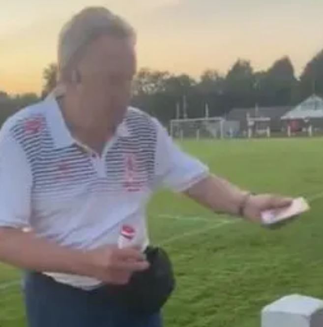 Neil Warnock hands out a signed autographed picture from his bum bag to a fan