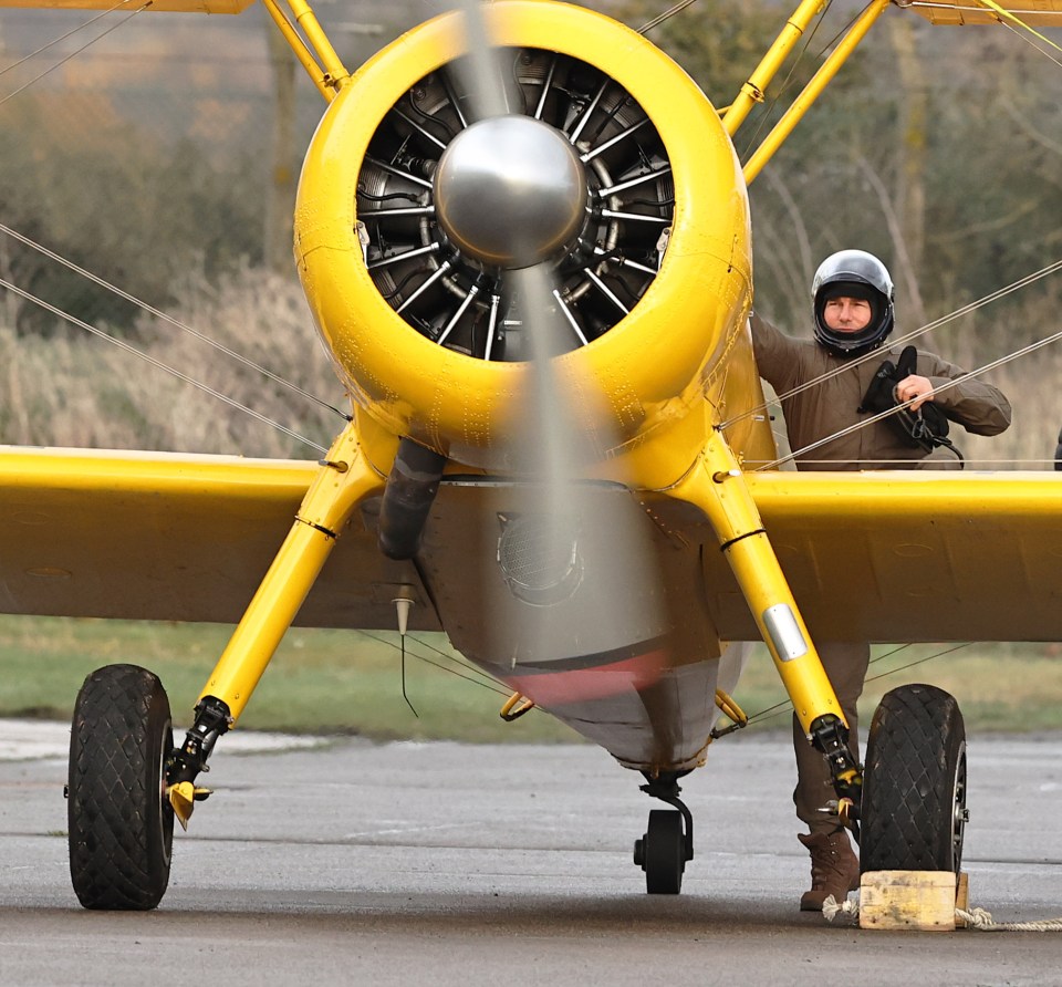 He climbed into the historic biplane wearing a dark flightsuit and helmet