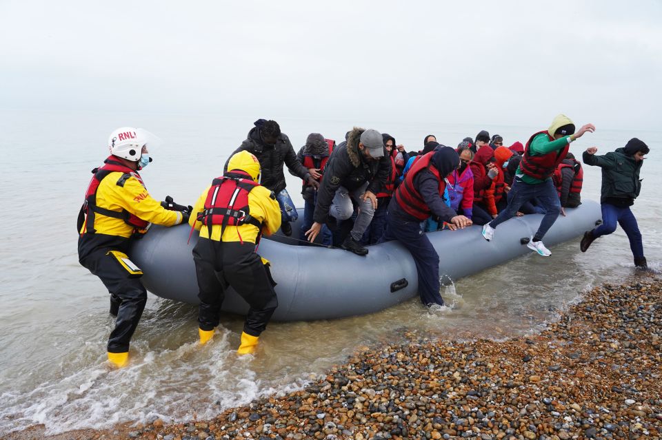 Many destroy their documents before arrival - pictured migrants helped ashore by lifeboat crew members on November 20th 2021