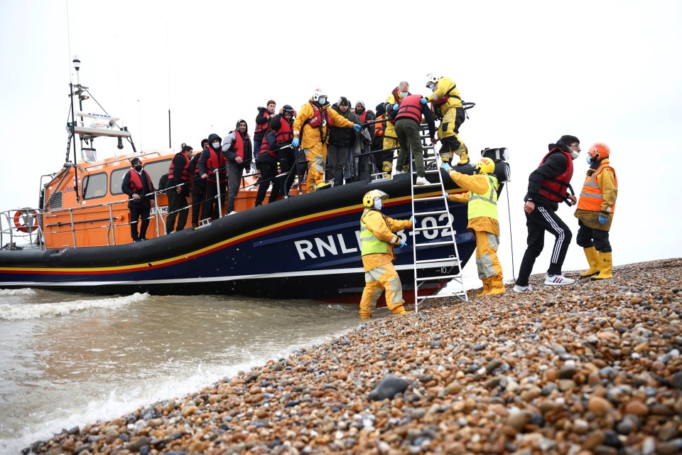 Migrants are helped ashore from an RNLI beach in Dungeness