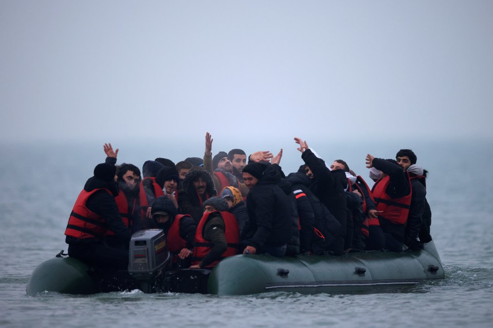 A group of more than 40 migrants react as they succeeded to get on an inflatable dinghy