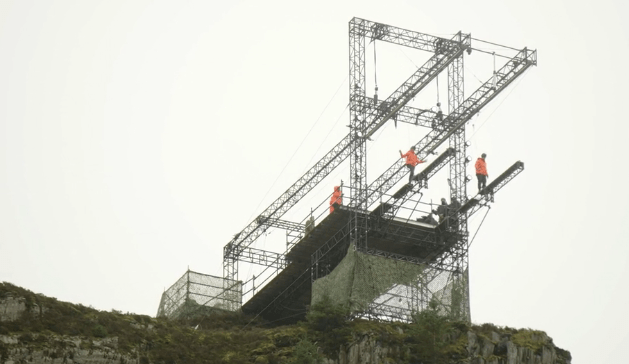 Contestants walk out from a platform high above the ground