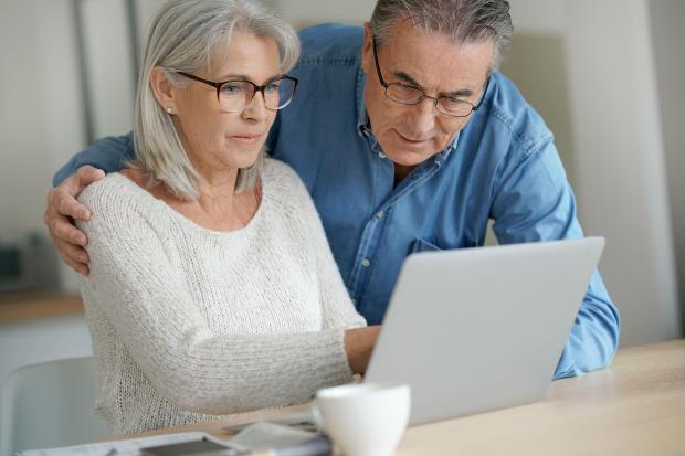 a man and woman are looking at a laptop together