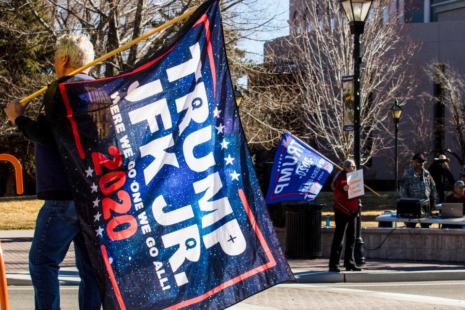 QAnon supports wave flags with Trump/JFK Jr. 2020 emblazoned across them