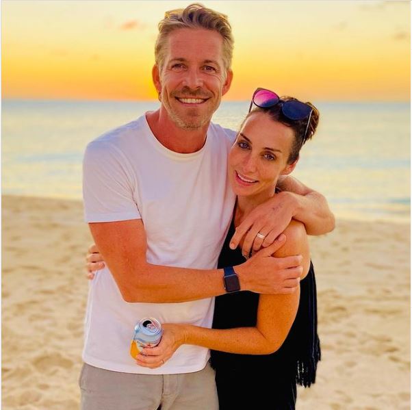 Couple embracing on a beach at sunset.