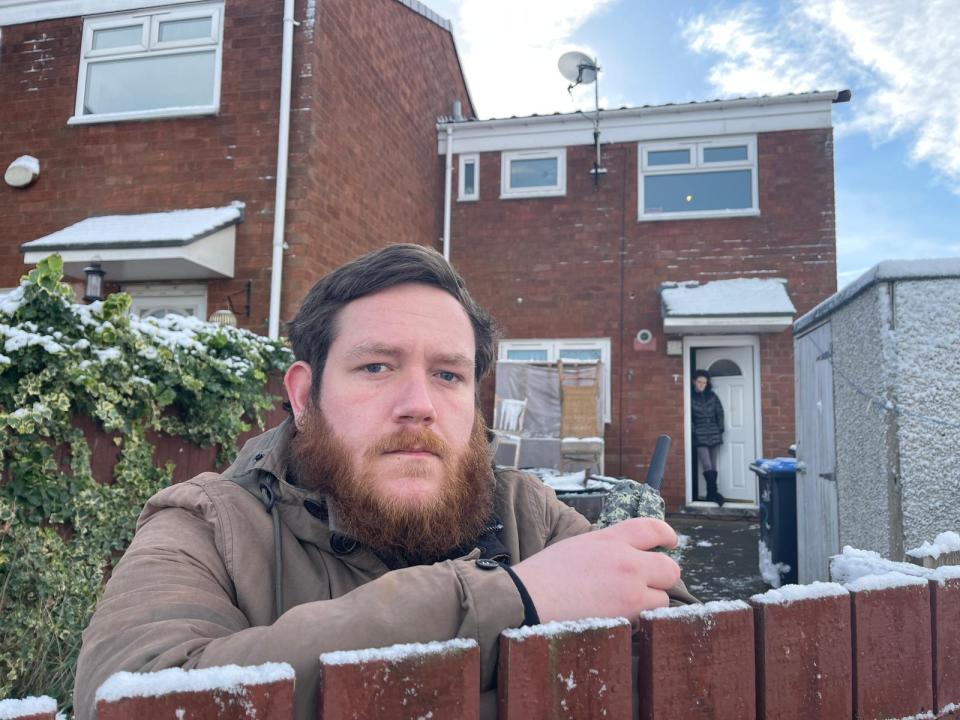 Jack Hobson, 28, standing guard outside his property