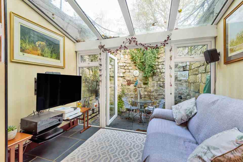 Huge glass doors lead out to a perfectly manicured garden