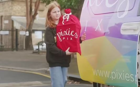 Girl donating a large box of toys.