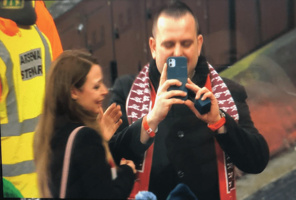 The couple grin and bear it after Gunnersaurus stole some of their photo glory