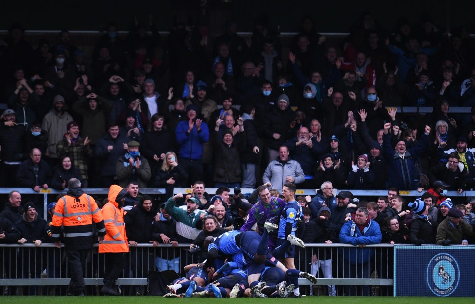 Cult hero Adebayo Akinfenwa launched himself on top of his team-mates in front of an ecstatic home crowd