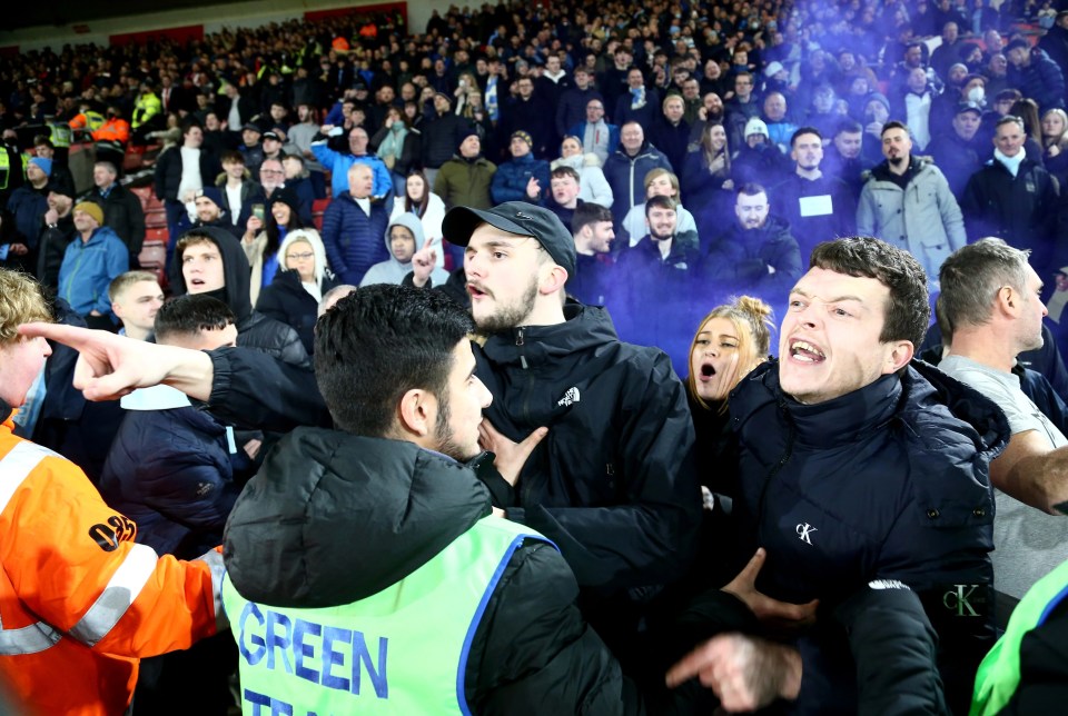 Three away supporters got onto the pitch as flares were set off