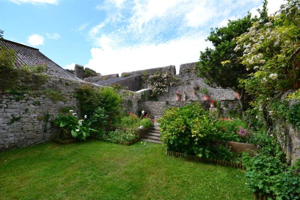 The beautifully landscaped garden boasts a medieval wall