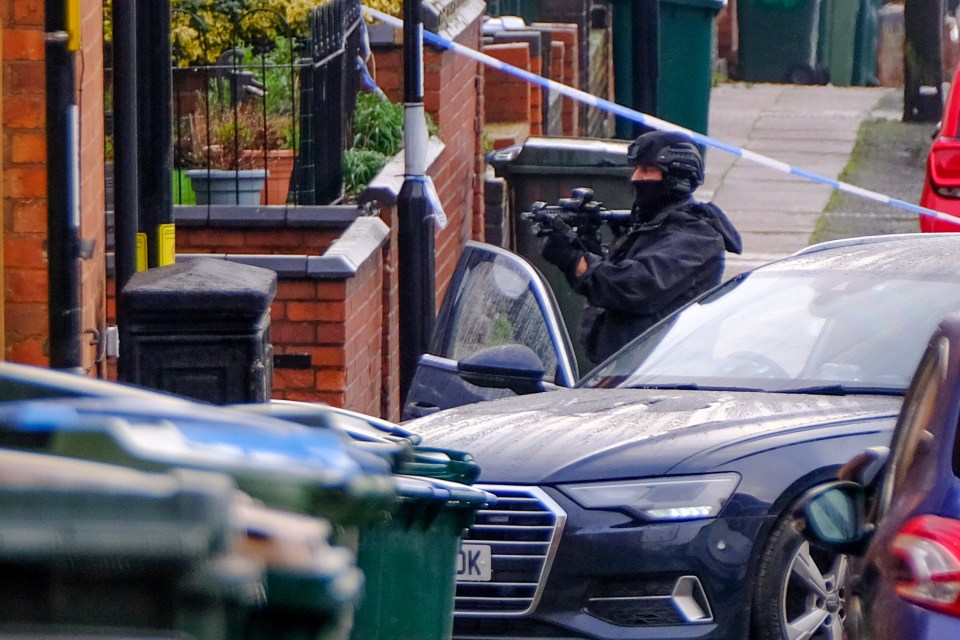 A policeman points with a gun into the home