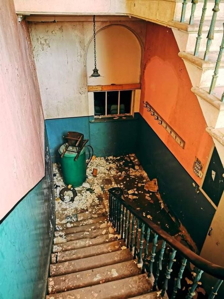 Plaster has fallen from the ceilings and a chair is tossed into the corner