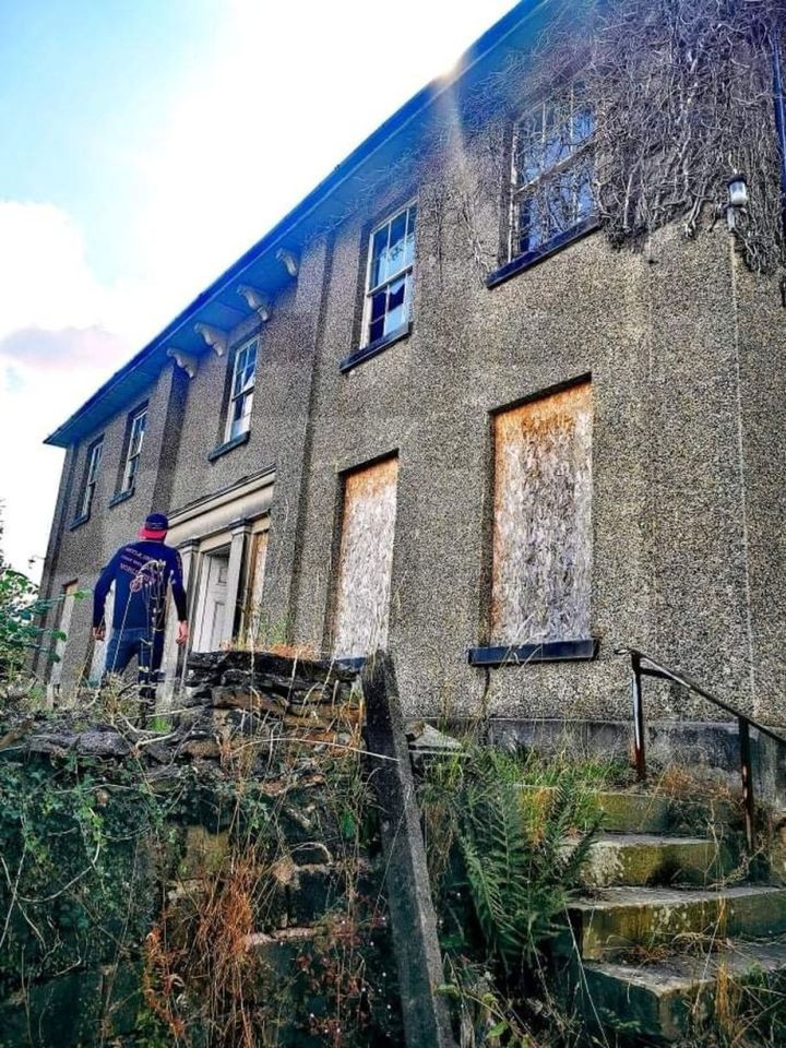 The mansion in Derbyshire is boarded up with some smashed windows