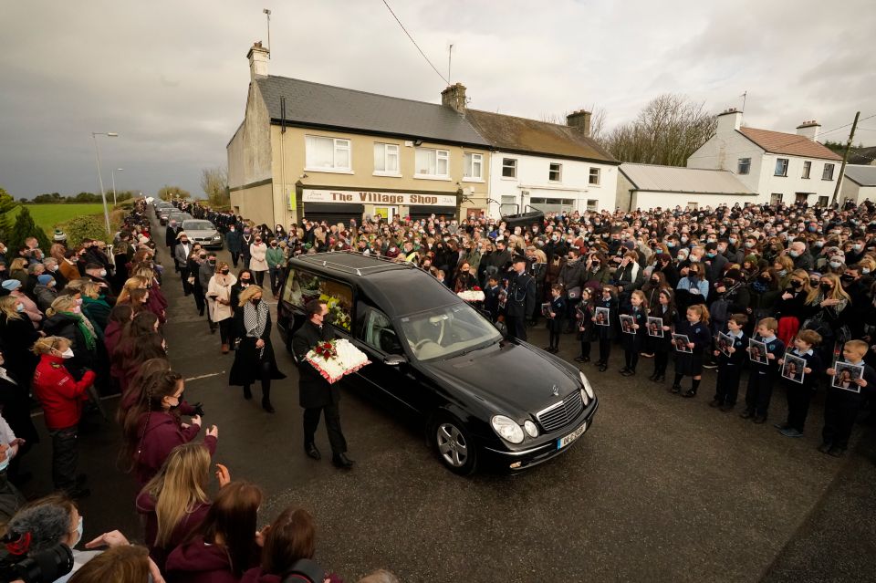 Mourners walk beside the hearse for the funeral of Ashling Murphy