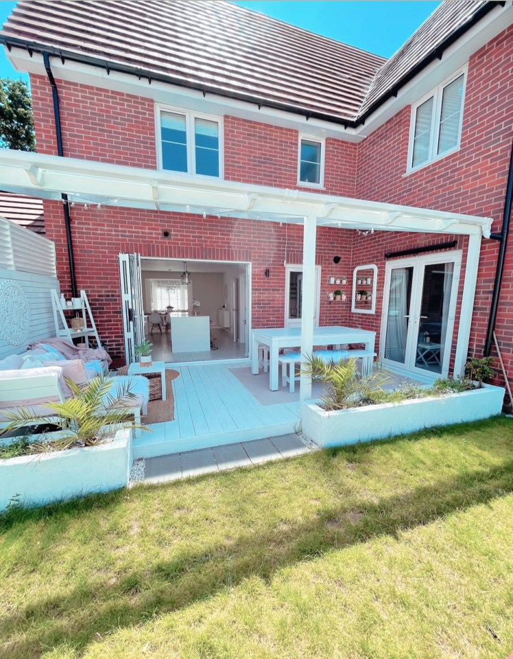 A white wooden patio gives the garden a beachy feel