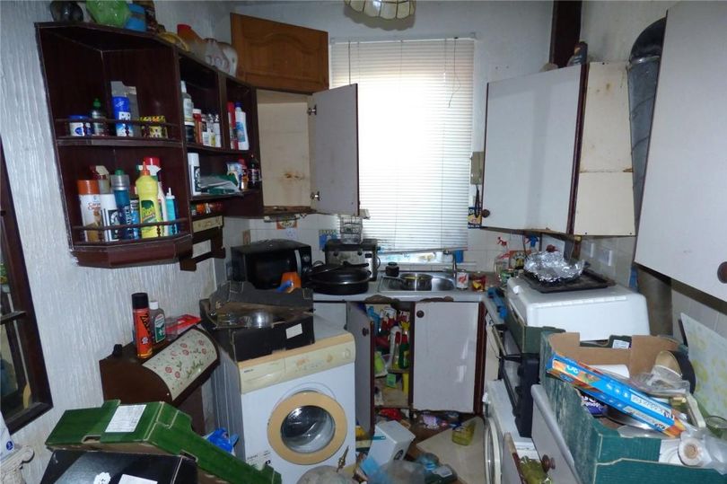 The kitchen is crammed with boxes and rubbish