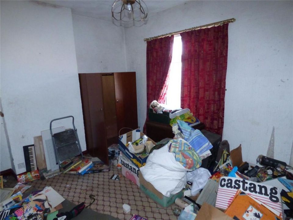 A third bedroom crammed with boxes and rubbish