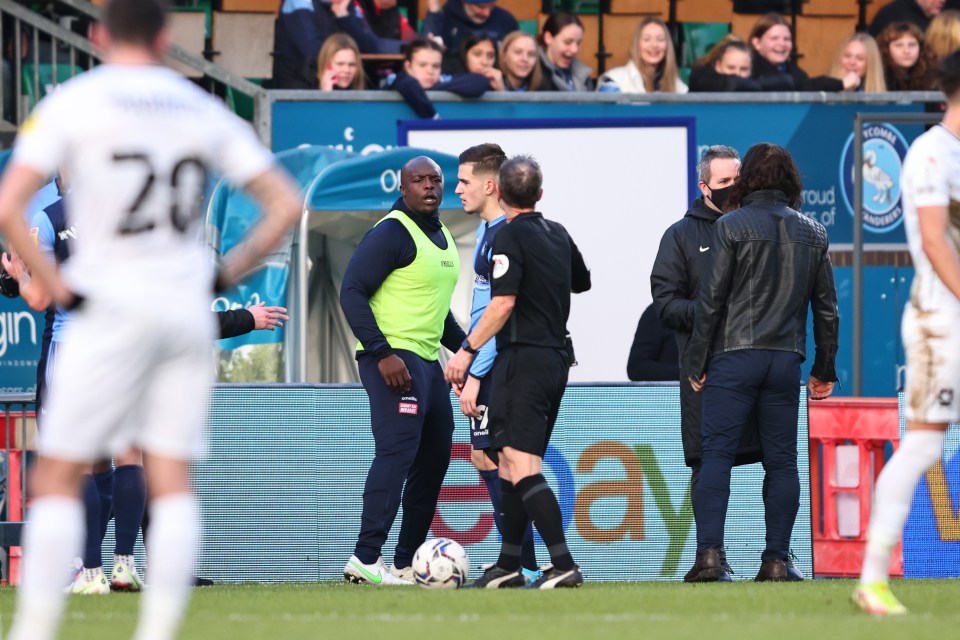 An irate Akinfenwa speaks to referee Robert Lewis after he brought a halt to play