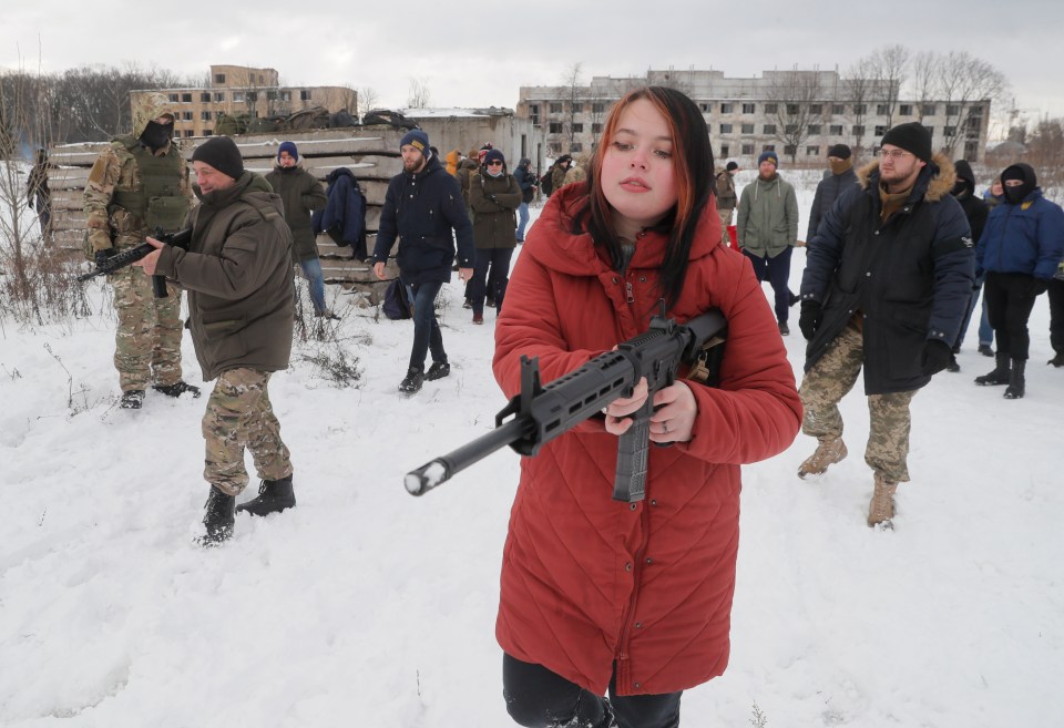 A child in Kiev get to grips with a gun as as Russia threatens to invade Ukraine