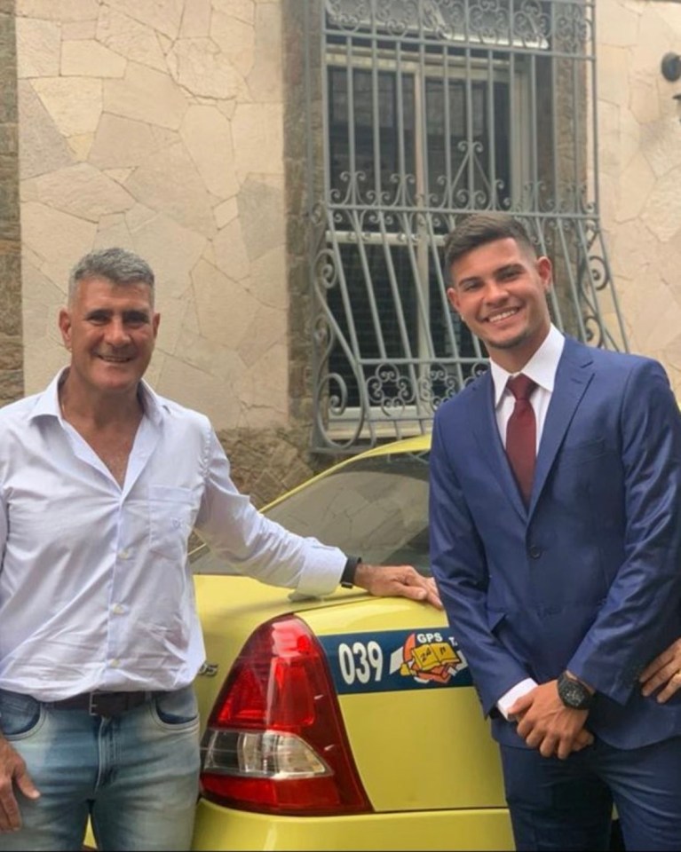 Guimaraes (R) and his father, Dick, next to his taxi