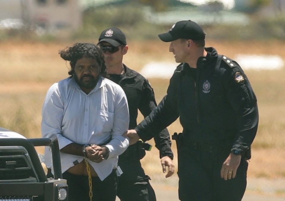 Terence Darrell Kelly boards a plane after being taken into custody