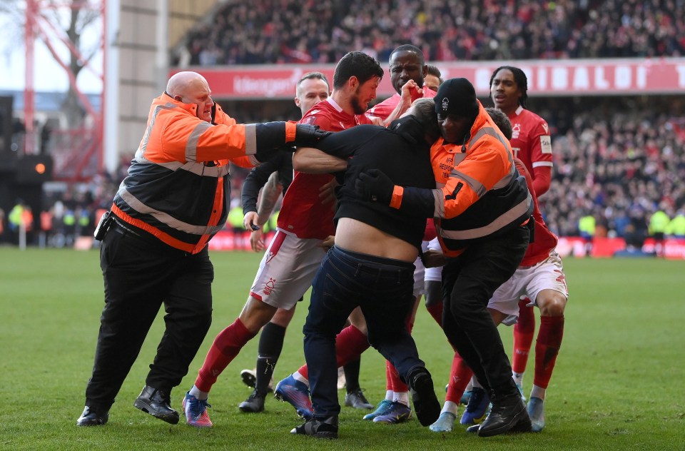 A pitch invader has been charged with assaulting three Nottingham Forest players