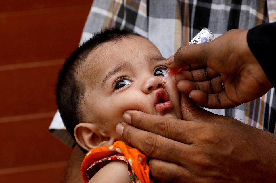 A girl receives polio vaccine drops in Karachi, Pakistan July 20, 2020. The new case of polio in Africa has links to Pakistan, where the virus is endemic