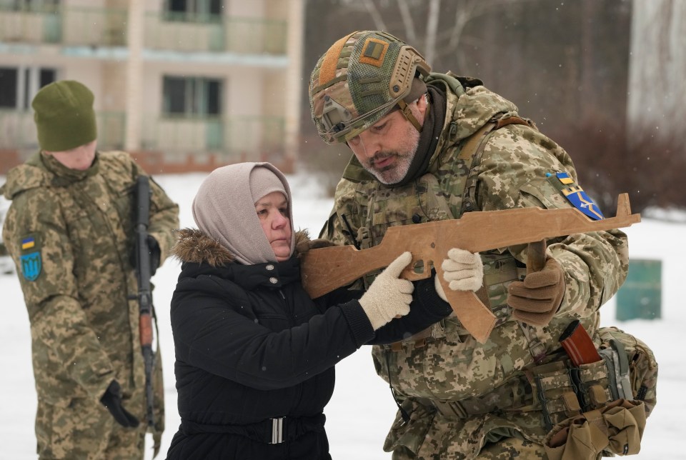 The drill instructor helps the gran with her wooden assault rifle