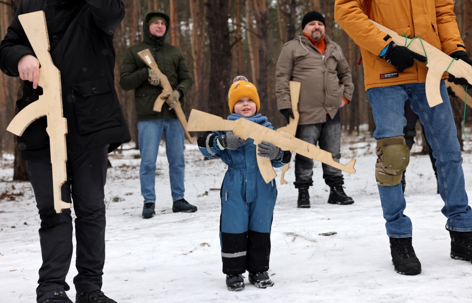 The little lad is preparing to do his part as he joins in the drills