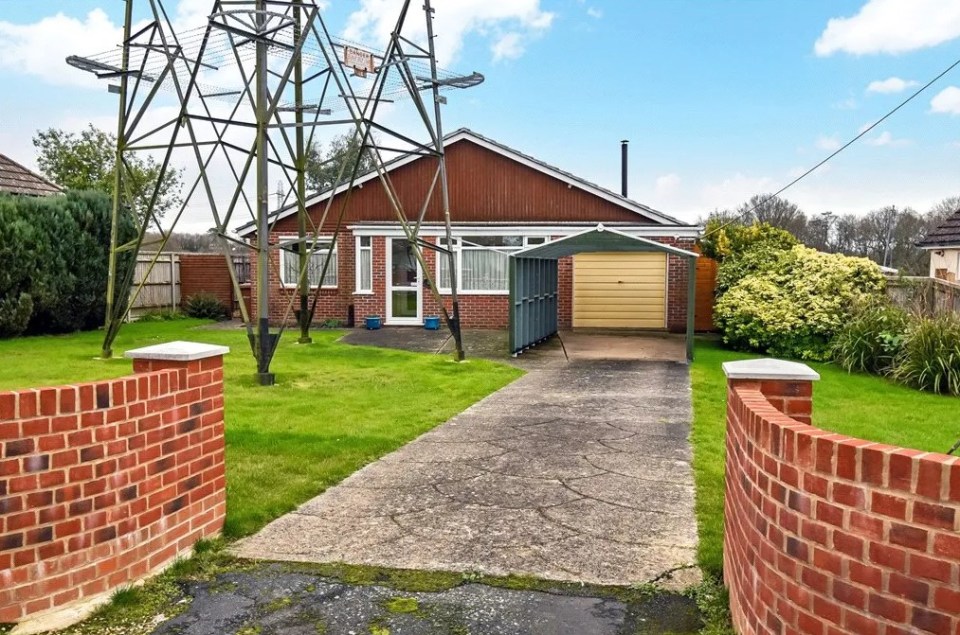 A bungalow for sale for £350,000 has a giant pylon in the front garden