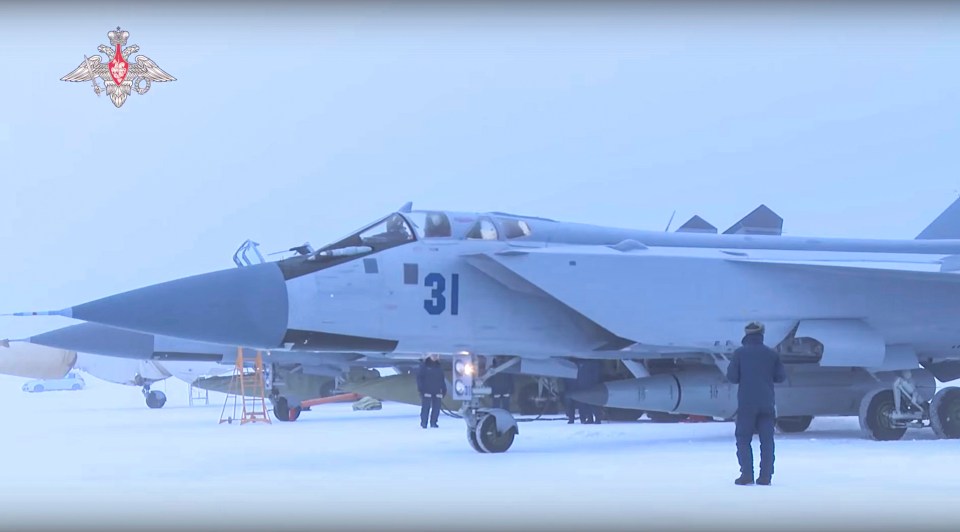 Russian servicemen examining Kinzhal hypersonic missiles before a flight of a fighter jet