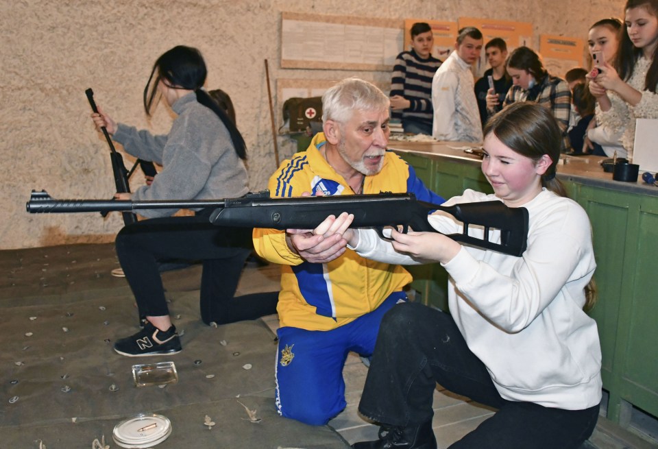 Ukrainian high school students being taught how to fire guns by a former soldier