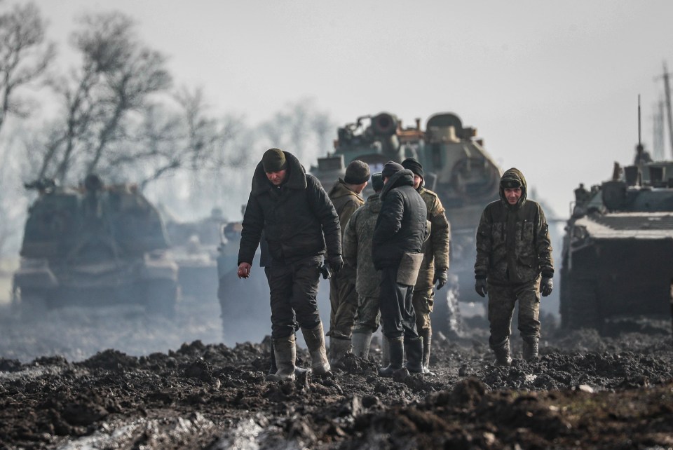 Russian servicemen and armoured vehicles stand on the road in Rostov region, Russia