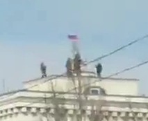 Russian soldiers raise a flag in Kharkiv